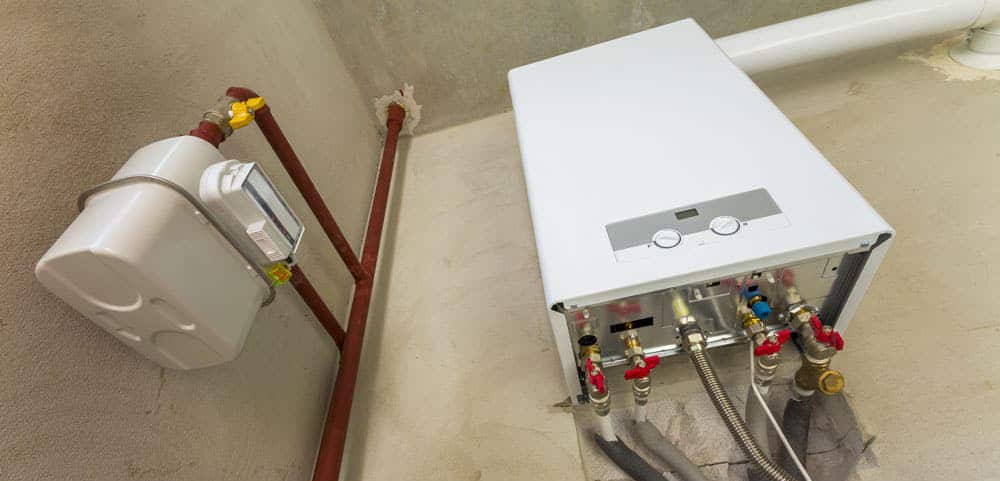 Front view of a boiler system installed on the wall with pipes running from unit throughout house.