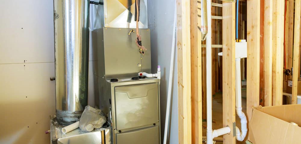 Front view of a furnace heating system installed in the basement of a new residential home.