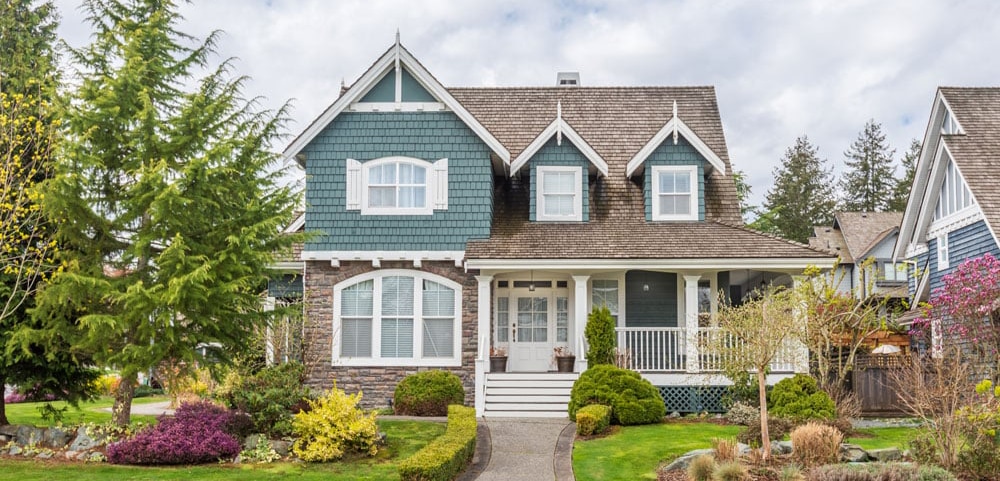Exterior shot of a beautiful two-story home with blue siding and brick in Bob’s service area of Central Wisconsin.